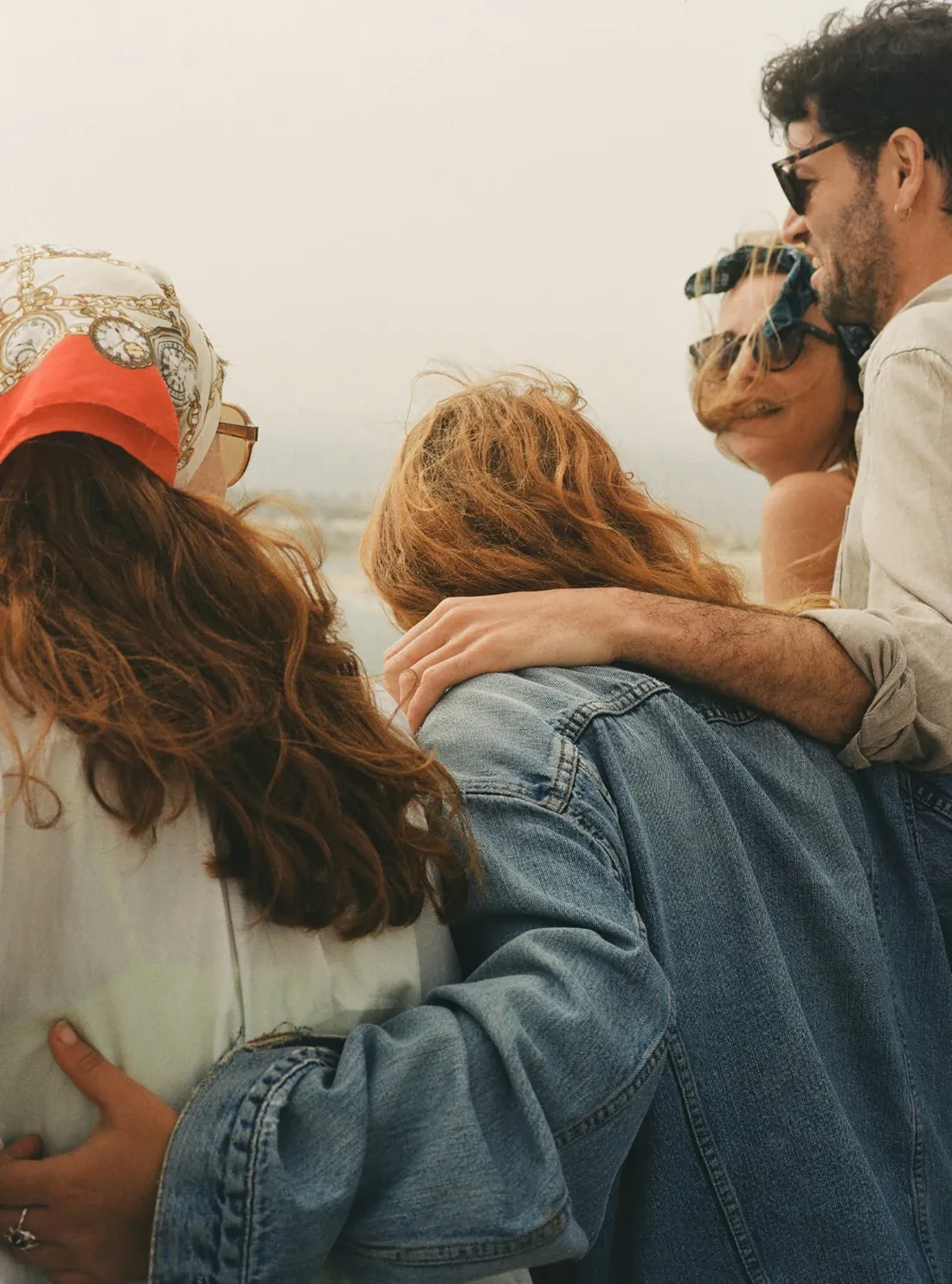Friends with arms around each other outdoors